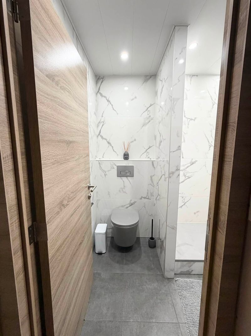 WC suspendus dans une pièce en carrelage effet marbre